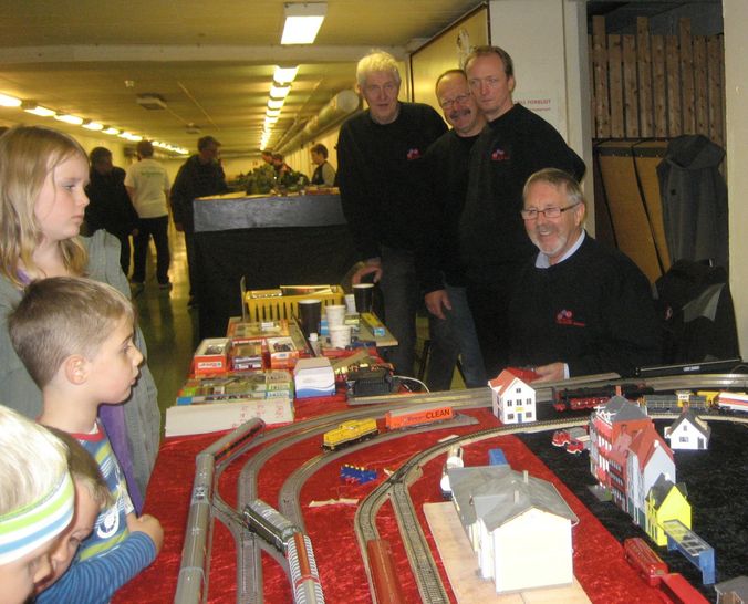 Torbjørn Pedersen (fra v.), Ernst Clemet, Laszlo Kiss og Bjørn Otto Hansen fra Hobbygruppen viser et engasjert publikum modelljernbanen. 